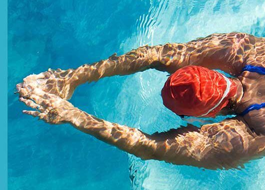 Las piscinas son el refugio favorito de muchas personas para disfrutar del verano. Sin embargo, cuando su mantenimiento no se realiza de manera adecuada o se acude a ellas con frecuencia, se puede producir una indeseable irritación y picor de ojos. ¿Qué función tiene el cloro en las piscinas? Para mantener correctamente una piscina, se requiere un nivel de pH adecuado, similar al de nuestra piel. Así evitamos que el agua sea demasiado ácida y produzca irritación, a la vez que permitimos que los desinfectantes actúen de forma adecuada eliminando virus, bacterias y microorganismos indeseados. Entre los desinfectantes más habituales se encuentra el cloro, que puede administrarse directamente o producido a partir de agua salada. El problema con este producto químico es que, al mezclarse con el material orgánico del agua (nitritos fundamentalmente, como por ejemplo: restos de sudor, orina, etc.), da lugar a un compuesto denominado cloramina. Esta sustancia es la responsable de irritar nuestras mucosas, nuestra piel y principalmente nuestros ojos. El riesgo de irritación es directamente proporcional a los restos orgánicos que se hayan depositado en el agua y a la concentración de cloro administrada. Es decir, cuanto más cloro añadamos porque creemos que más desinfección se requiere, más cloraminas se producirán y, por tanto, más posibilidad de irritación. ¿Qué produce el cloro? En estos ambientes donde existe una alta concentración de cloro, es muy posible experimentar irritación, escozor y prurito, que aumentarán con la manipulación, por ejemplo, por efecto del rascado. Además, pueden aparecer lagrimeo e incluso fotofobia. Además, una piscina que huele a cloro no suele ser sinónimo de un correcto mantenimiento. La presencia cloraminas y de suciedad puede no solo irritar los ojos, sino también dar lugar a conjuntivitis vírica o bacteriana. ¿Cómo prevenir el ojo rojo? La conjuntivitis alérgica que se produce por la irritación causada por las cloraminas sobre nuestra superficie ocular puede ser prevenida siguiendo una serie de recomendaciones: - Cambiar el desinfectante: existen desinfectantes alternativos, como el oxígeno activo o el bromo, que no producen compuestos secundarios que afecten a la superficie ocular, las mucosas o la piel. - Medidas de protección: siempre es recomendable el uso de gafas de natación o de buceo cuando utilicemos una piscina. Posteriormente y como norma, sería adecuado darnos una ducha y realizar una limpieza cuidadosa de nuestros ojos con agua no clorada. - Piscinas y lentillas: no suele tratarse de una buena combinación. Se recomienda no utilizar lentillas de forma habitual en la piscina. Si las usamos, los riesgos aumentan, puesto que la lente de contacto retiene una pequeña cantidad de agua de la piscina, que puede acantonar los microorganismos, los cuales, con el calor, se replicarán con mayor facilidad. Consejos para aliviar el ojo rojo Si no has podido evitar que tus ojos se irriten, aquí va una serie de consejos de higiene ocular: ● Enjuaga tus ojos con agua fría: para eliminar el residuo del agua clorada y evitar que permanezca en tus ojos, deberías enjuagarlos con agua fría. Esto eliminará las trazas de cloramina u otros compuestos que puedan causar la irritación. ● Restaura la humedad de tus ojos: una solución salina de gotas oftálmicas puede aliviar los síntomas leves y disminuir la inflamación e irritación. ● Utiliza productos específicos de ojos sensibles para realizar una higiene diaria.