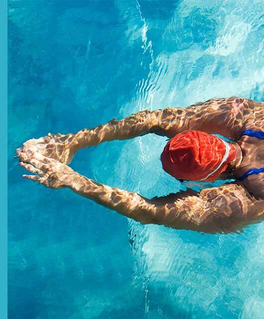 Las piscinas son el refugio favorito de muchas personas para disfrutar del verano. Sin embargo, cuando su mantenimiento no se realiza de manera adecuada o se acude a ellas con frecuencia, se puede producir una indeseable irritación y picor de ojos. ¿Qué función tiene el cloro en las piscinas? Para mantener correctamente una piscina, se requiere un nivel de pH adecuado, similar al de nuestra piel. Así evitamos que el agua sea demasiado ácida y produzca irritación, a la vez que permitimos que los desinfectantes actúen de forma adecuada eliminando virus, bacterias y microorganismos indeseados. Entre los desinfectantes más habituales se encuentra el cloro, que puede administrarse directamente o producido a partir de agua salada. El problema con este producto químico es que, al mezclarse con el material orgánico del agua (nitritos fundamentalmente, como por ejemplo: restos de sudor, orina, etc.), da lugar a un compuesto denominado cloramina. Esta sustancia es la responsable de irritar nuestras mucosas, nuestra piel y principalmente nuestros ojos. El riesgo de irritación es directamente proporcional a los restos orgánicos que se hayan depositado en el agua y a la concentración de cloro administrada. Es decir, cuanto más cloro añadamos porque creemos que más desinfección se requiere, más cloraminas se producirán y, por tanto, más posibilidad de irritación. ¿Qué produce el cloro? En estos ambientes donde existe una alta concentración de cloro, es muy posible experimentar irritación, escozor y prurito, que aumentarán con la manipulación, por ejemplo, por efecto del rascado. Además, pueden aparecer lagrimeo e incluso fotofobia. Además, una piscina que huele a cloro no suele ser sinónimo de un correcto mantenimiento. La presencia cloraminas y de suciedad puede no solo irritar los ojos, sino también dar lugar a conjuntivitis vírica o bacteriana. ¿Cómo prevenir el ojo rojo? La conjuntivitis alérgica que se produce por la irritación causada por las cloraminas sobre nuestra superficie ocular puede ser prevenida siguiendo una serie de recomendaciones: - Cambiar el desinfectante: existen desinfectantes alternativos, como el oxígeno activo o el bromo, que no producen compuestos secundarios que afecten a la superficie ocular, las mucosas o la piel. - Medidas de protección: siempre es recomendable el uso de gafas de natación o de buceo cuando utilicemos una piscina. Posteriormente y como norma, sería adecuado darnos una ducha y realizar una limpieza cuidadosa de nuestros ojos con agua no clorada. - Piscinas y lentillas: no suele tratarse de una buena combinación. Se recomienda no utilizar lentillas de forma habitual en la piscina. Si las usamos, los riesgos aumentan, puesto que la lente de contacto retiene una pequeña cantidad de agua de la piscina, que puede acantonar los microorganismos, los cuales, con el calor, se replicarán con mayor facilidad. Consejos para aliviar el ojo rojo Si no has podido evitar que tus ojos se irriten, aquí va una serie de consejos de higiene ocular: ● Enjuaga tus ojos con agua fría: para eliminar el residuo del agua clorada y evitar que permanezca en tus ojos, deberías enjuagarlos con agua fría. Esto eliminará las trazas de cloramina u otros compuestos que puedan causar la irritación. ● Restaura la humedad de tus ojos: una solución salina de gotas oftálmicas puede aliviar los síntomas leves y disminuir la inflamación e irritación. ● Utiliza productos específicos de ojos sensibles para realizar una higiene diaria.